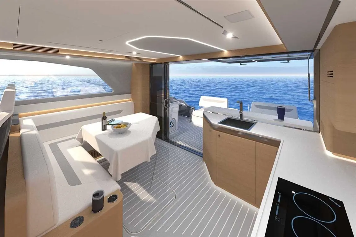 Modern yacht interior featuring a dining area with a table, wine bottle, and view of the ocean through large windows.